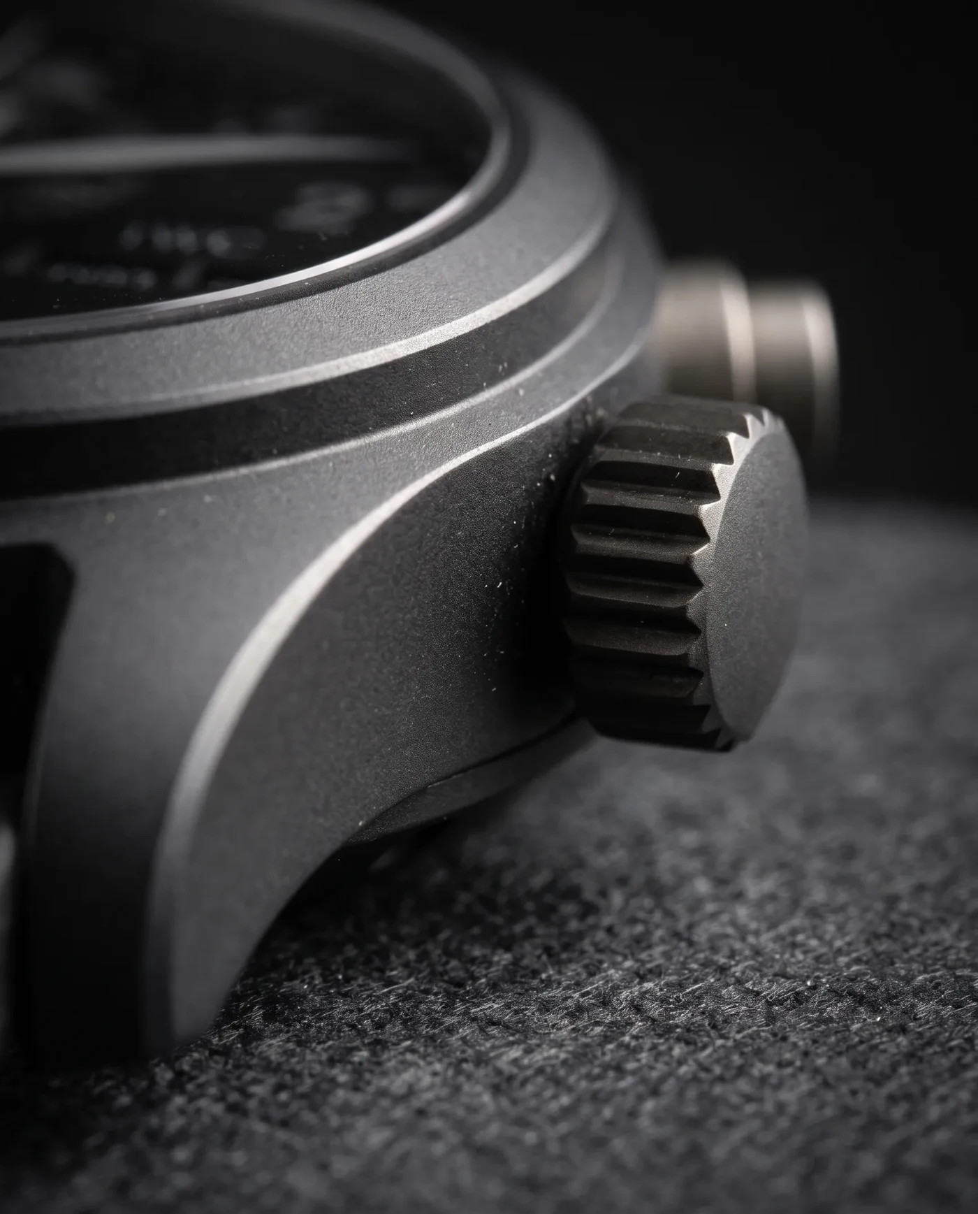 Close-up macro detail of an IWC Top Gun ceramic watch case and oversized crown, showing the matte ceramic texture